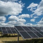 Solar panels in an open space under the sky full of clouds